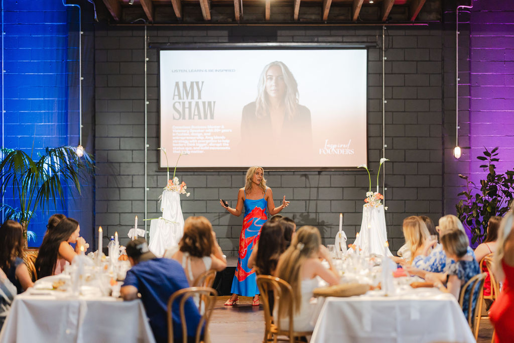 A speaker in a colourful dress sharing her story with the audience